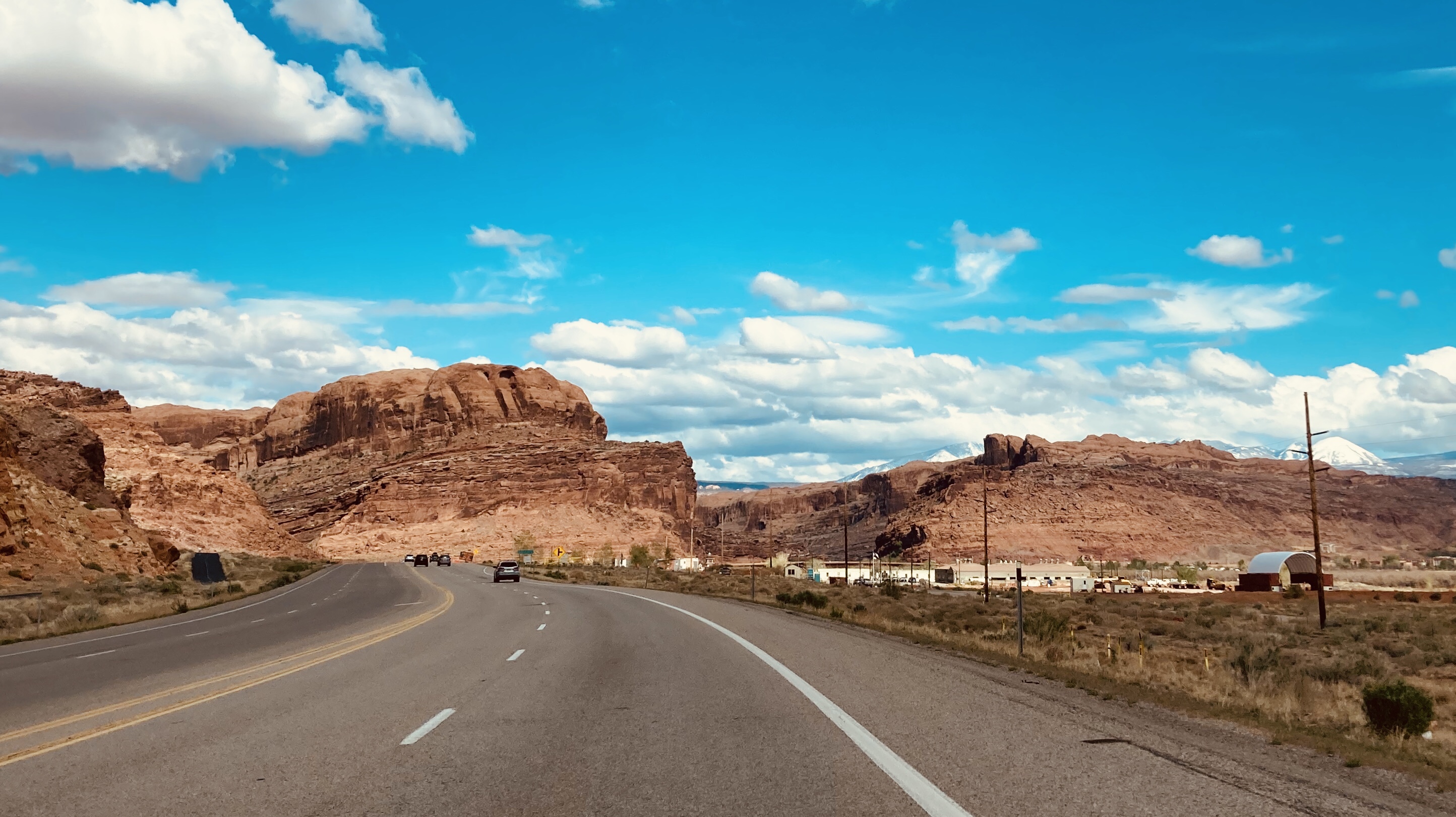 Photo taken from car of desert mesas and canyon mouth